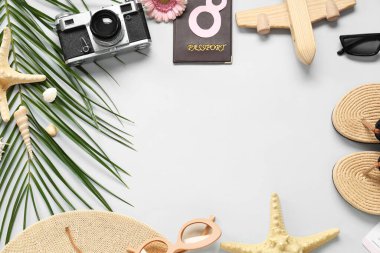 Plaj aksesuarlarından yapılmış çerçeve, fotoğraf makinesi ve gri arka planda palmiye yaprağı. Uluslararası Kadınlar Günü