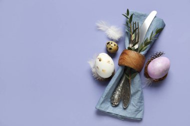 Paskalya yumurtası ve leylak arkaplanlı tüylü sofra takımı.