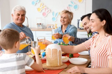 Mutlu bir aile mutfakta Paskalya yemeği yiyor.