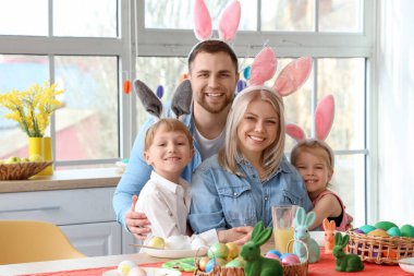 Tavşan kulaklı mutlu aile Paskalya günü evde sarılıyor.