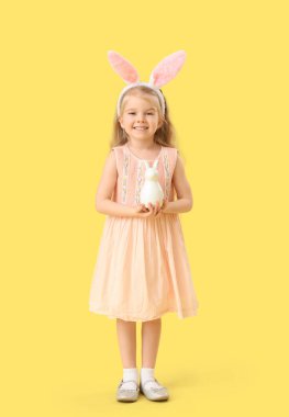 Tavşan kulaklı küçük kız, sarı arka planda Paskalya tavşanı.