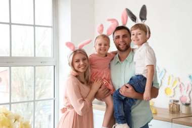 Tavşan kulaklı mutlu aile Paskalya günü evde sarılıyor.