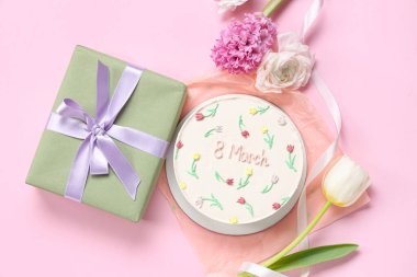 Hediye kutulu tatlı bento keki ve pembe arka planda güzel çiçekler. Uluslararası Kadınlar Günü