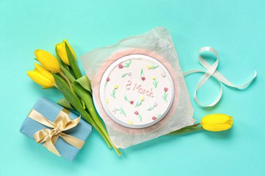 Hediye kutulu tatlı bento keki, güzel laleler ve turkuaz arka planda sekizinci figür. Uluslararası Kadınlar Günü
