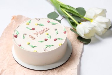 Güzel laleli tatlı bento keki ve beyaz arka planda yapraklar. Uluslararası Kadınlar Günü