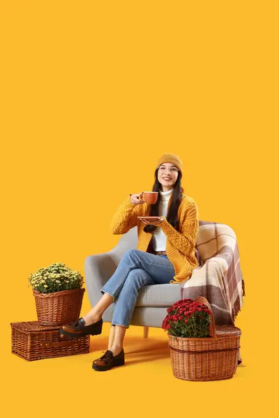 Stilvolle Junge Frau Mit Chrysanthemenblüten Trinkt Kaffee Sessel Auf Gelbem — Stockfoto