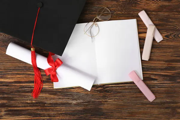 Tahta arka planda diploma, kitap ve gözlüklü havan mermisi tahtası.
