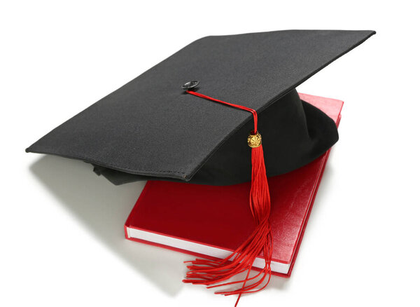 Mortar board and book on white background