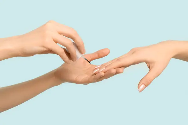 Mãos Femininas Segurando Escova Com Óleo Cutícula Fundo Azul — Fotografia de Stock