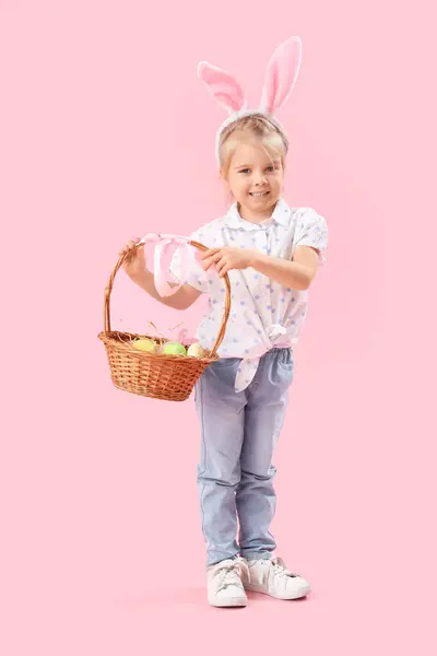 戴着粉色背景复活节彩蛋的兔子耳朵小女孩 — 图库照片