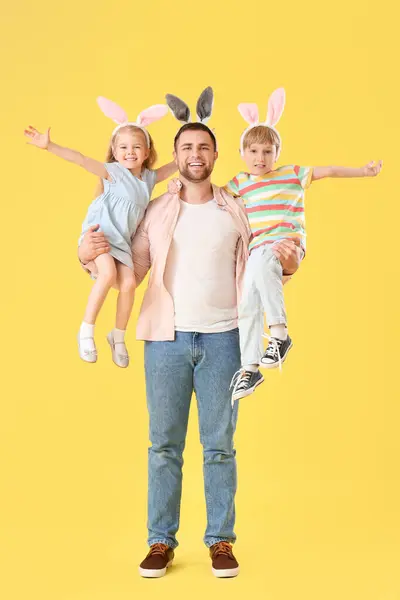 Gelukkige Vader Met Zijn Kleine Kinderen Konijntjes Oren Gele Achtergrond — Stockfoto