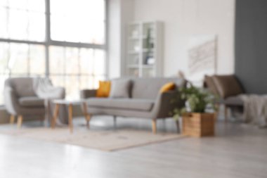 Rahat kanepesi ve koltuğu olan, bulanık manzaralı, şık bir oturma odası.