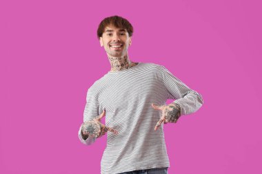 Mor arka planda karnını gösteren genç bir adam.