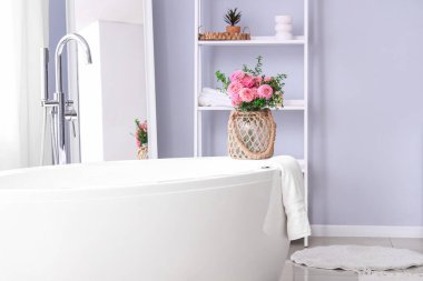 Wicker vazosu dolusu güzel pembe yıldız çiçekleri banyoda