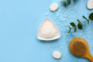 Renkli arkaplanda deniz tuzu, masaj fırçası ve okaliptüs dallarıyla kompozisyon