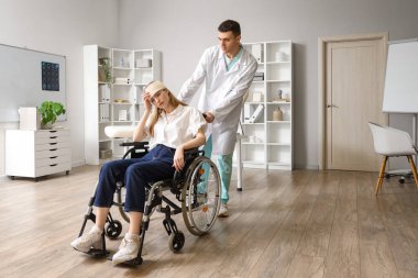 Tekerlekli sandalyede beyin sarsıntısı geçiren genç bir kadın ve hastanede doktor.