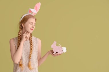 Paskalya tavşanı kulaklı ve renkli kağıttan tavşanı olan genç bir kız.