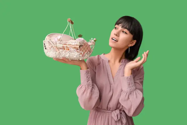 Verrast Jonge Vrouw Met Pasen Mand Met Cosmetica Groene Achtergrond — Stockfoto