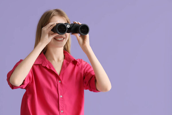 Молодая женщина с биноклем на сиреневом фоне