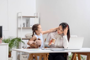 Ofiste çalışan yorgun annesi olan küçük bir kız.