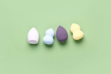 Yeşil arkaplanda farklı makyaj süngerleri