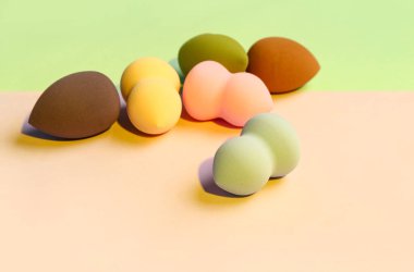 Renkli arkaplanda farklı makyaj süngerleri