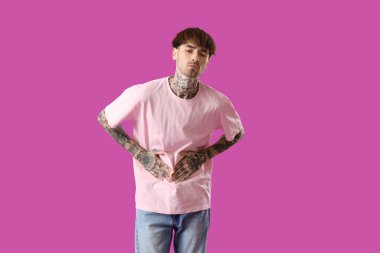 Mor arka planda karın ağrısı çeken genç bir adam.