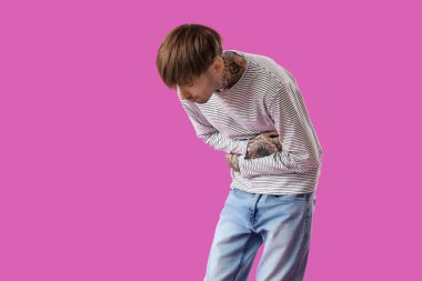 Mor arka planda karın ağrısı çeken genç bir adam.