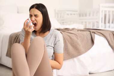 Yatak odasında doğum sonrası depresyondan muzdarip bebek monitörlü kızgın genç bir kadın.