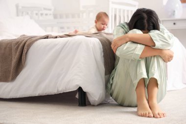 Bebeği olan genç bir kadın yatak odasında doğum sonrası depresyon geçiriyor.