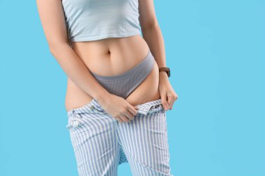 Mavi arka planda dar kotlu genç bayan, yakın plan. Kilo alma kavramı