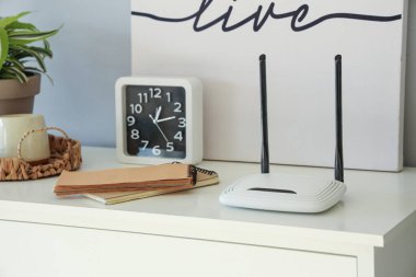 Odadaki klozet ve klozet üzerindeki defter ve saate sahip modern wi-fi yönlendirici, yakın plan