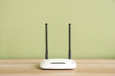 Yeşil duvarın yanındaki rafta modern wi-fi yönlendirici
