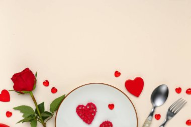 Kalpli güzel bir masa ve bej arka planda kırmızı gül. Sevgililer Günü kutlaması