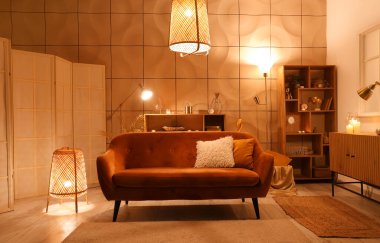 Parlayan lambalar ve gece kanepesi olan şık bir oturma odası.