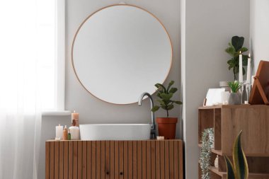 İçinde yanan mumlar, ayna ve lavabo olan şık bir banyo.