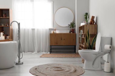 İçinde yanan mumlar, lavabo ve klozet olan şık bir banyo.