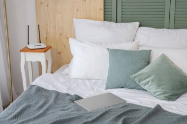 Odanın başucundaki masada modern kablosuz ağ yönlendirici.