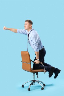 Mavi arka planda ofis koltuğunda komik bir işadamı