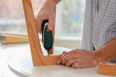 Tornavidayla evde kahve masası hazırlayan genç adam, yakın plan.