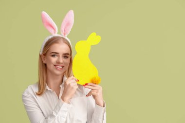 Paskalya tavşanı kulaklı ve renkli kağıttan tavşanı olan genç bir kız.