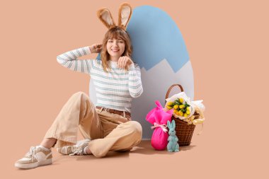 Tavşan kulaklı genç kız bej arka planda Paskalyayı kutluyor