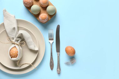 Güzel masa düzenleyicisi ve mavi arka planda Paskalya yumurtaları.