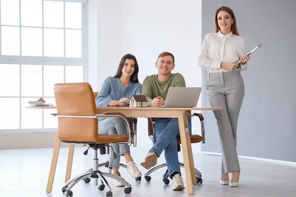Real estate agent working with couple in office