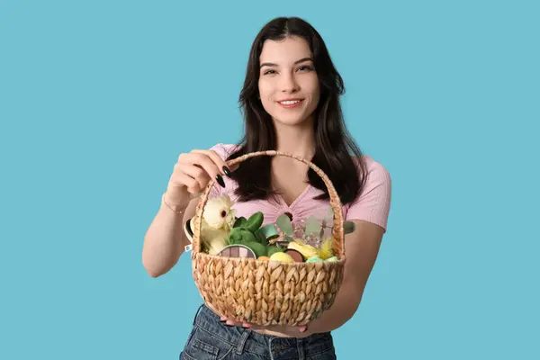 Hübsche Junge Frau Hält Weidenkorb Mit Kosmetik Auf Blauem Hintergrund — Stockfoto