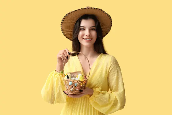 Hübsche Junge Frau Hält Weidenkorb Mit Kosmetik Auf Gelbem Hintergrund — Stockfoto