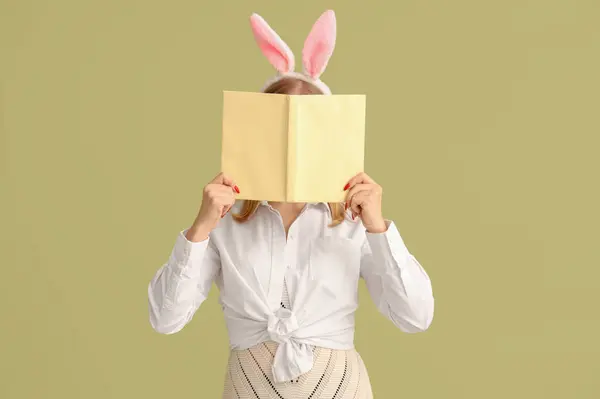 有复活节兔子耳朵和彩色背景书的小女孩 — 图库照片