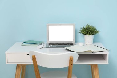 Renk duvarına yakın modern dizüstü bilgisayarı olan şık bir iş yeri