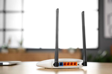 Modern Wi-Fi yönlendirici, ahşap masa, arka manzara.