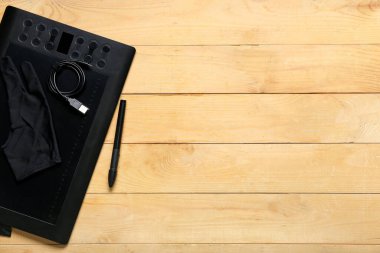Grafik tableti, stil, eldiven ve USB kablosu ahşap arka planda
